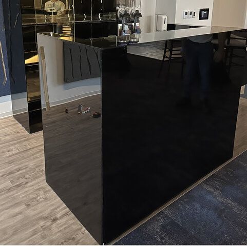 A Black Counter in a Kitchen With a Glass Top