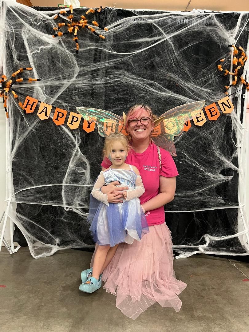 Girl with stethoscope plays doctor with toys on a table in a playroom.