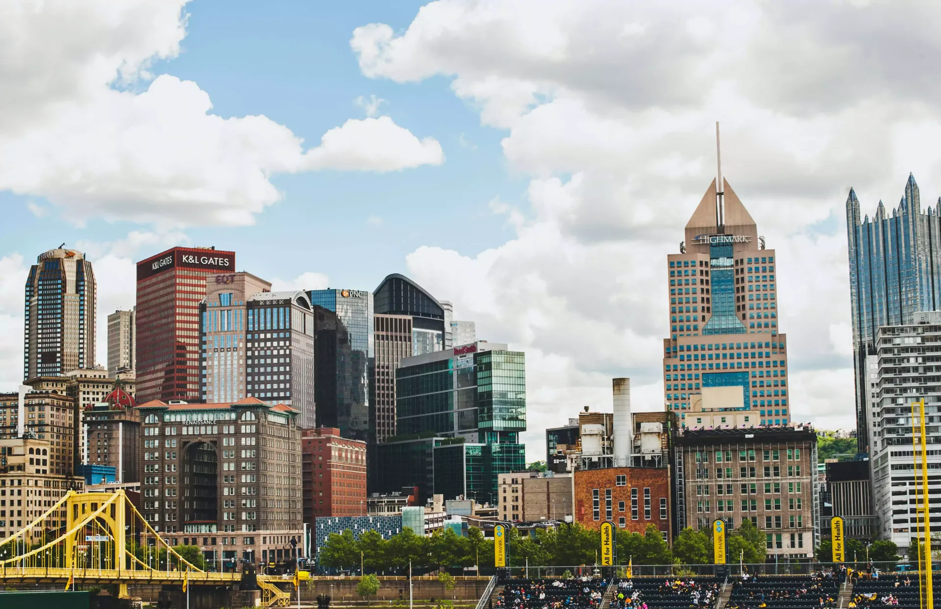 A city skyline with a bridge in the foreground and a river in the background.