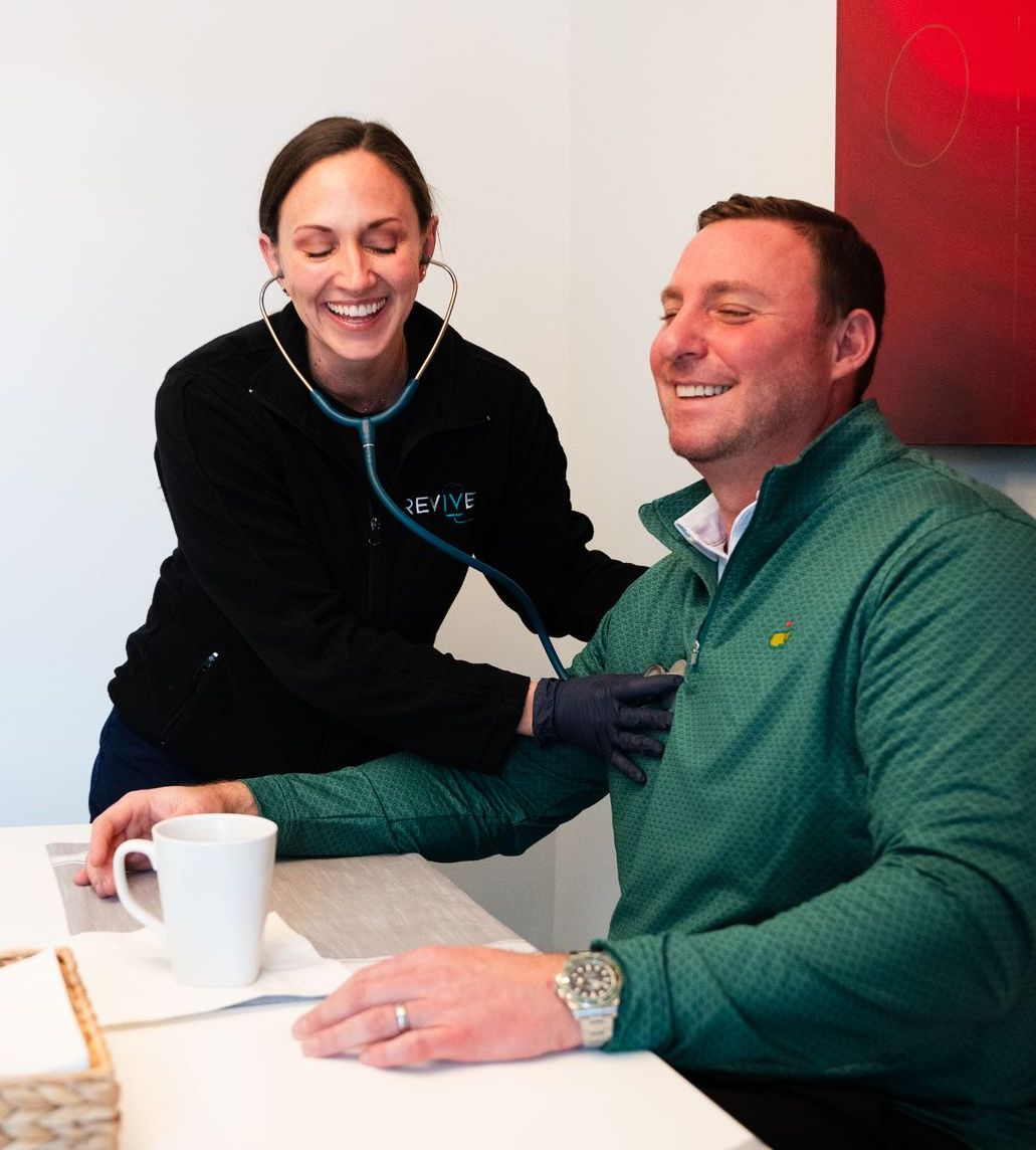A woman is listening to a man 's heartbeat with a stethoscope.