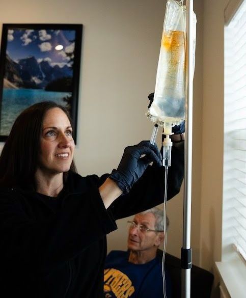 A woman is holding an iv bag in front of a window.