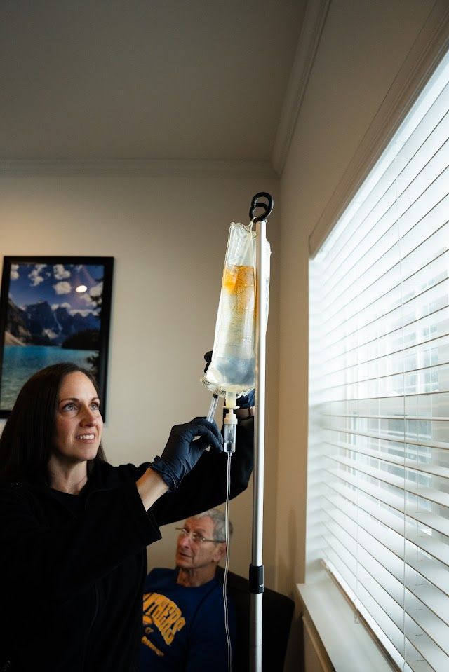 A woman is holding an iv bag in front of a window.