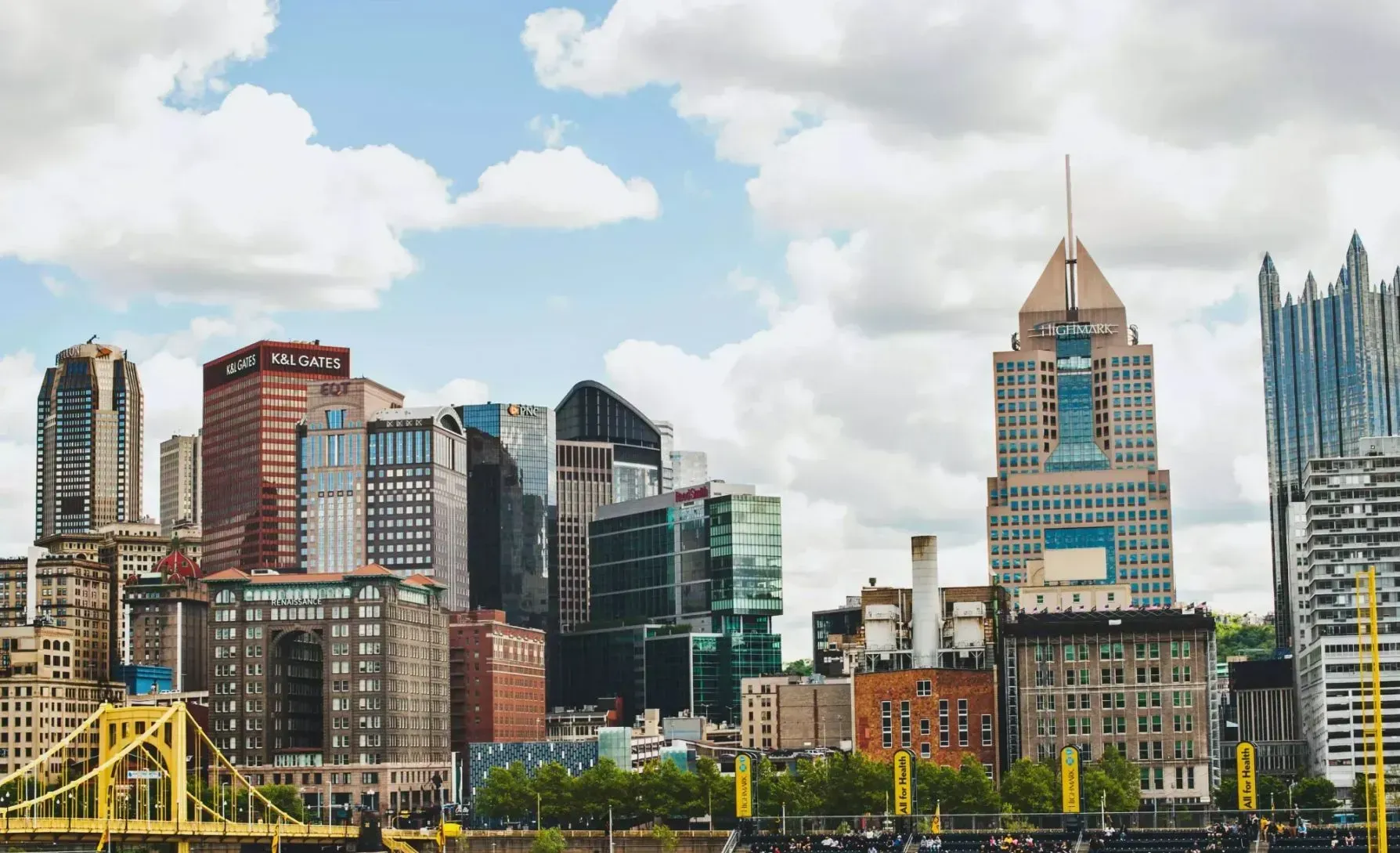 A city skyline with a yellow bridge in the foreground.