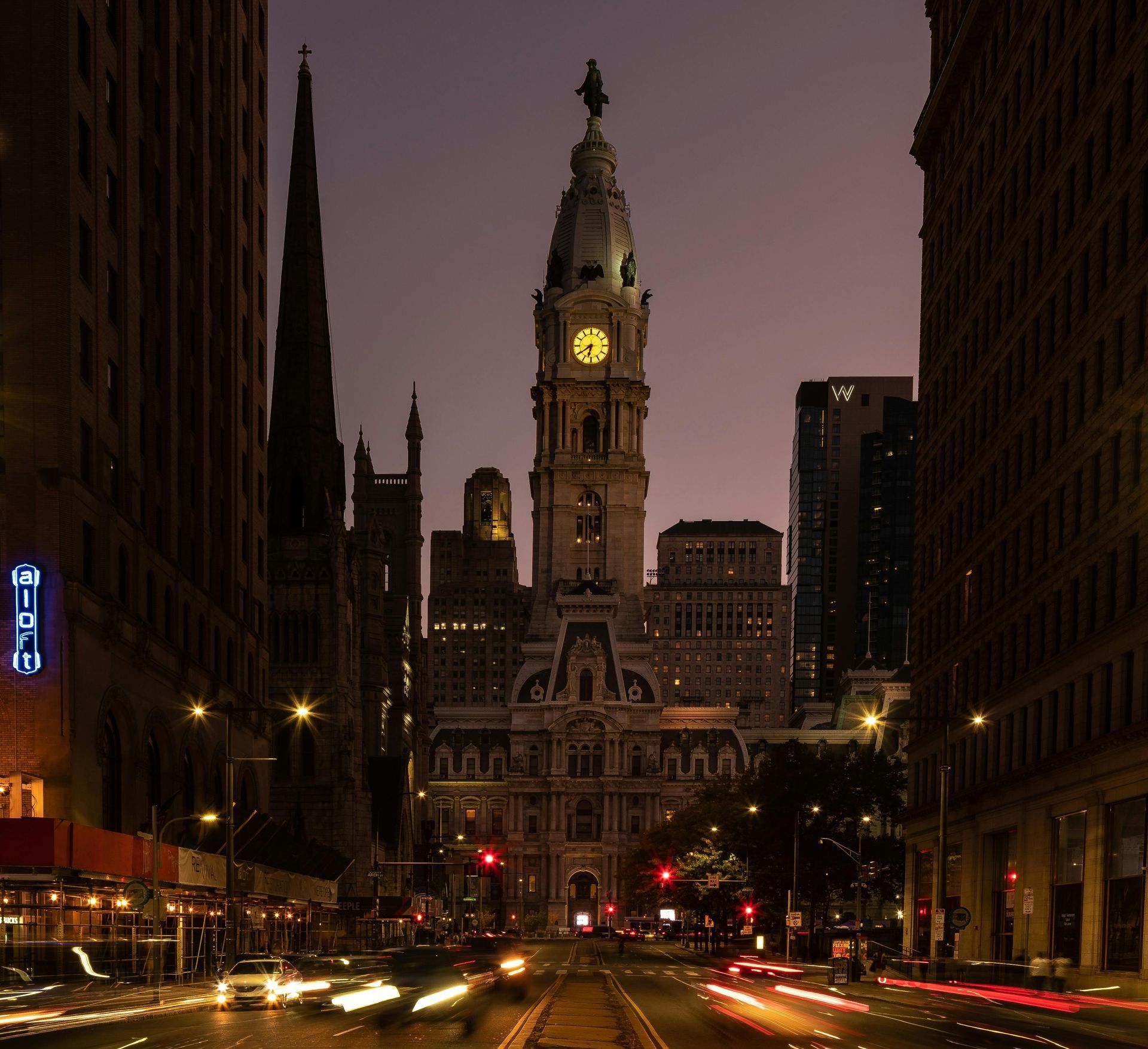 A clock tower in the middle of a city at night