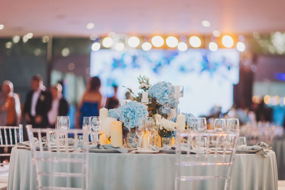 A table set for a wedding reception with flowers and candles on it.