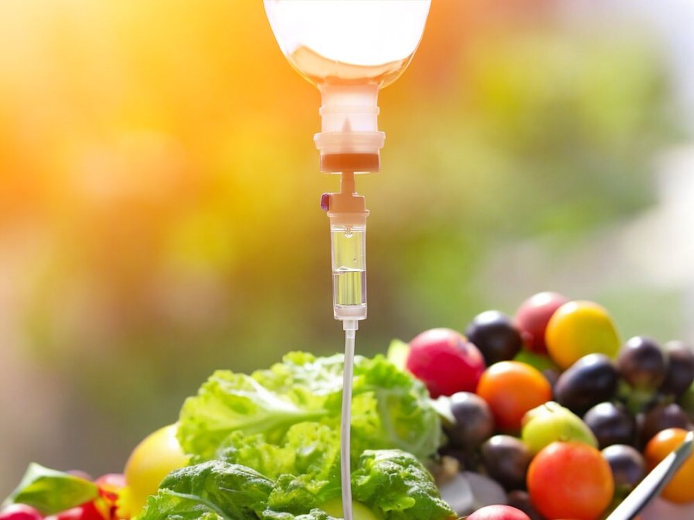 A plate of fruits and vegetables with a syringe attached to it.