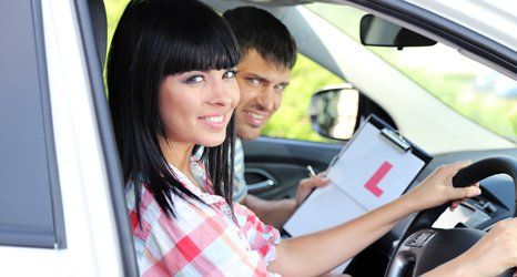 Beautiful young woman taking driving lesson.