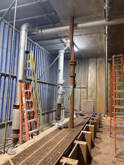 A close-up of a metal welding process, showing sparks and bright light where a rod connects to a dark metal fence frame.