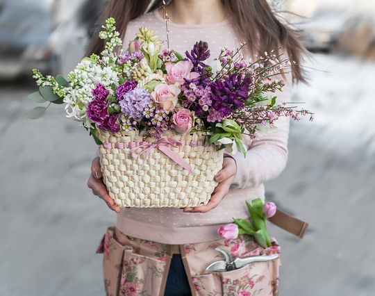 the florist holds beautiful basket of flowers