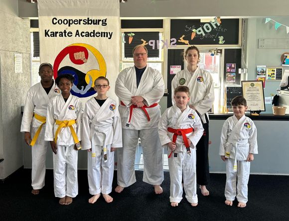Students  standing in front of a sign that says Coopersburg Karate Academy