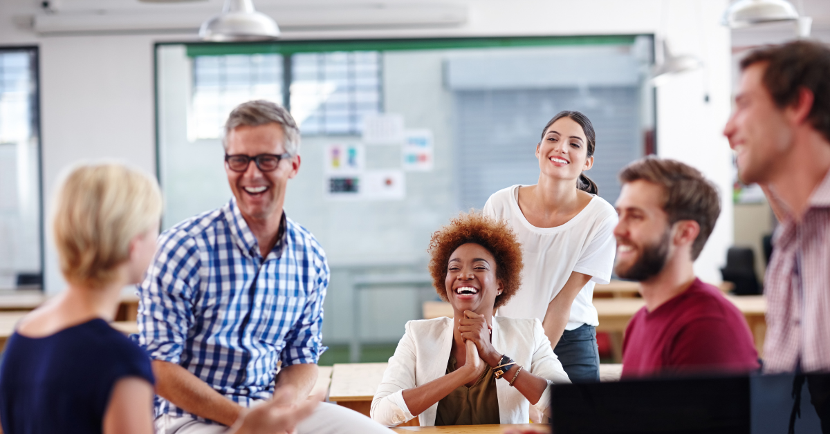 Group of professionals laughing together inside coworking area at Bridge Space Lee’s Summit