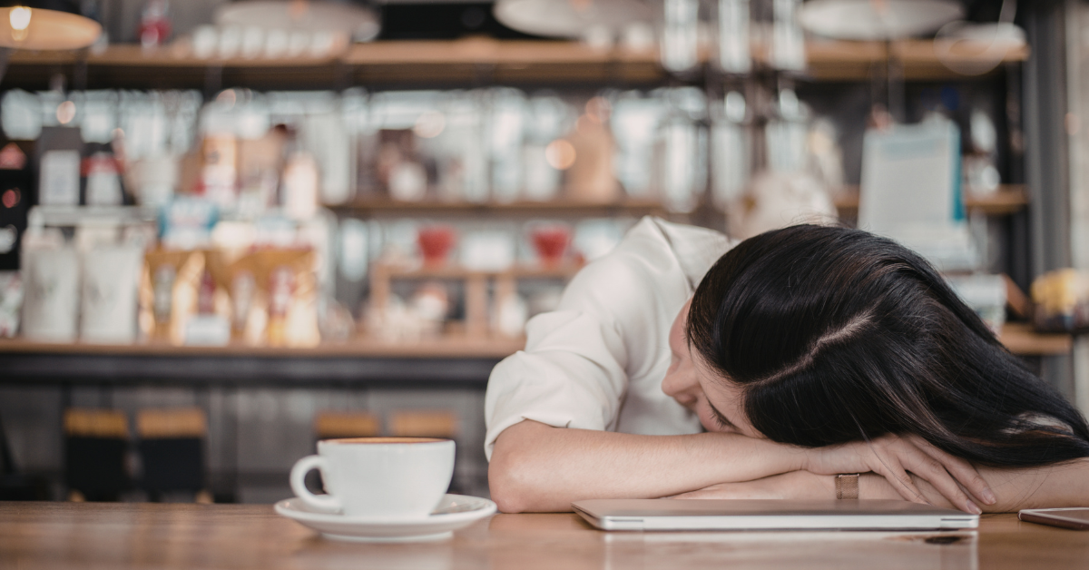 Tired professional working in coffee shop showing challenges of meeting clients in public spaces