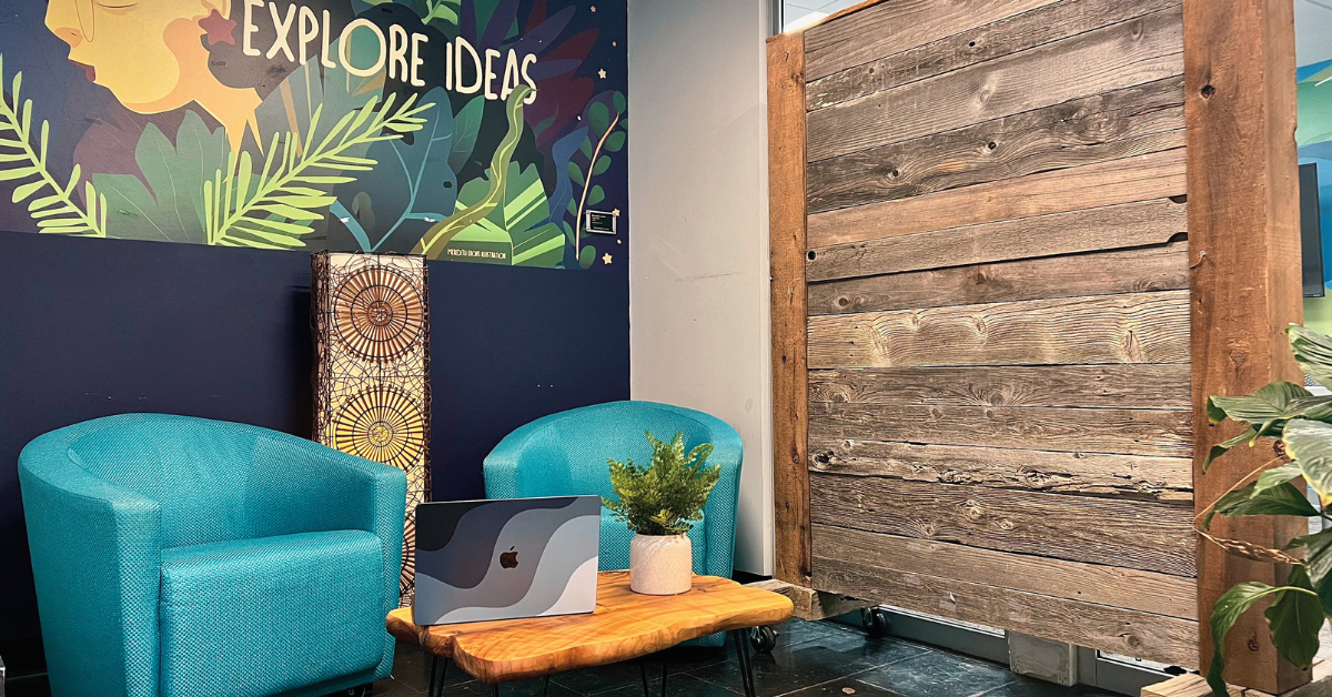 Cozy seating area inside Bridge Space featuring colorful mural art, natural textures, and a welcoming place to work or think.
