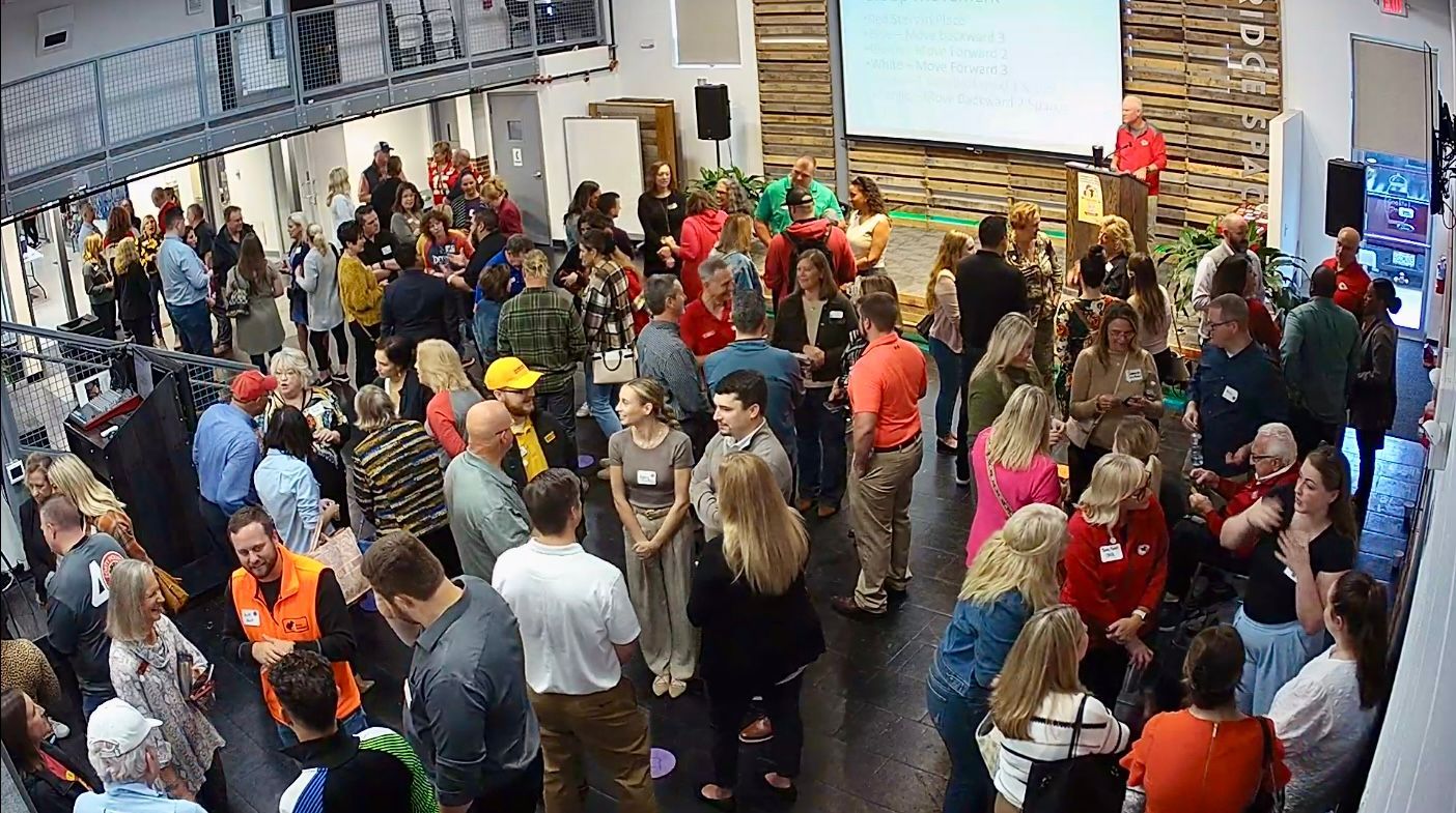 A large group of people are standing in a room.