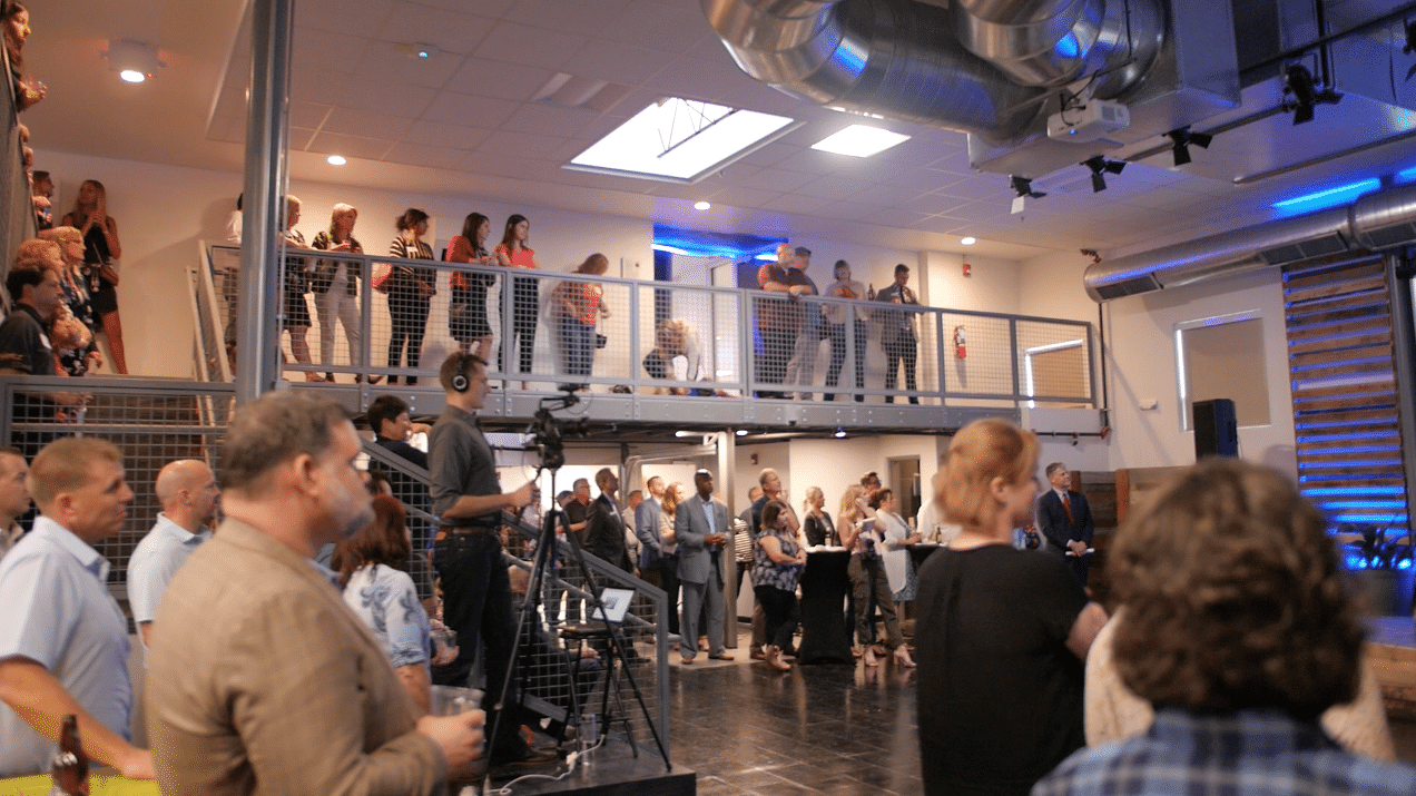 A large group of people are standing in a room.