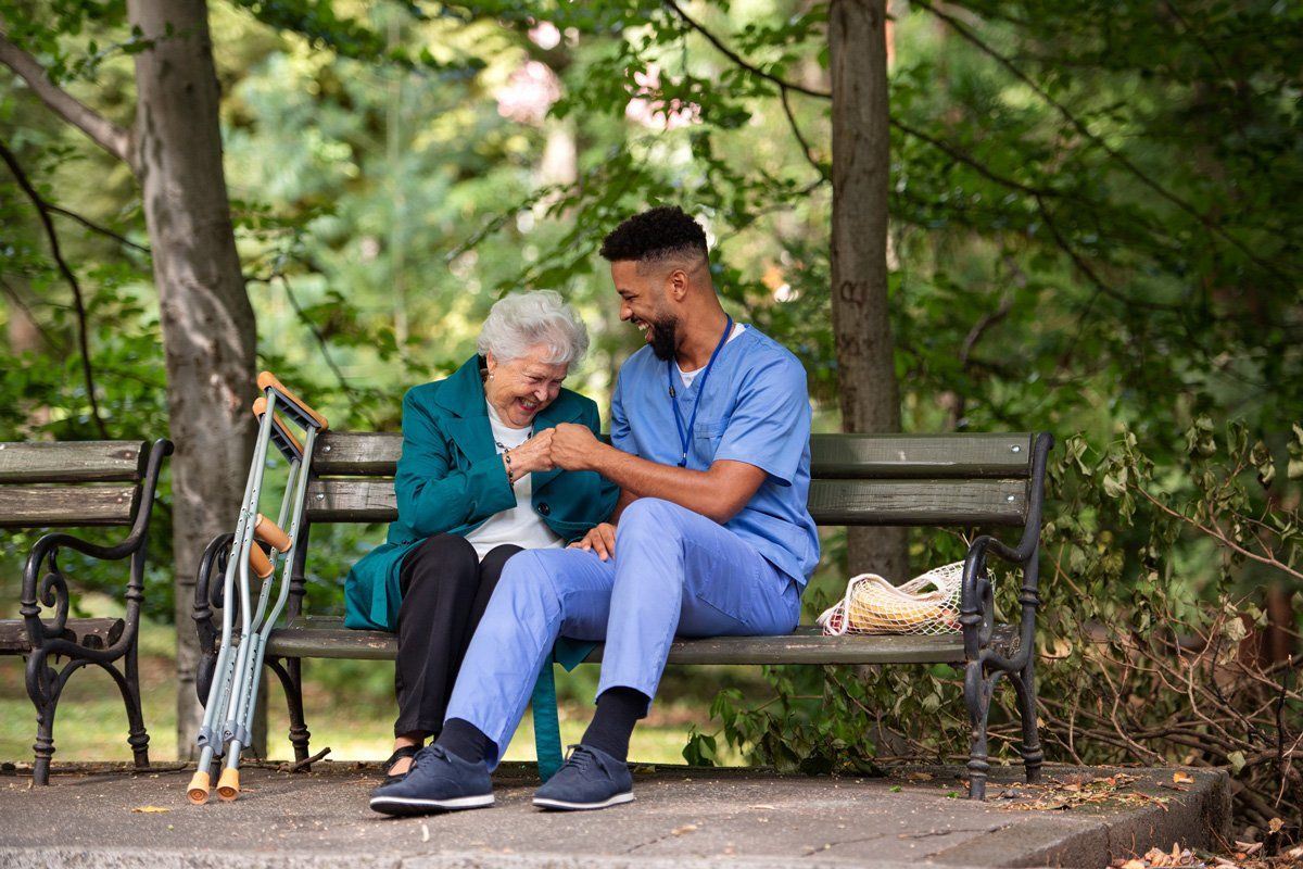 Man with Senior Woman with Crutches Sitting on Bench — St. Louis, MO — Medi-Plex HHC