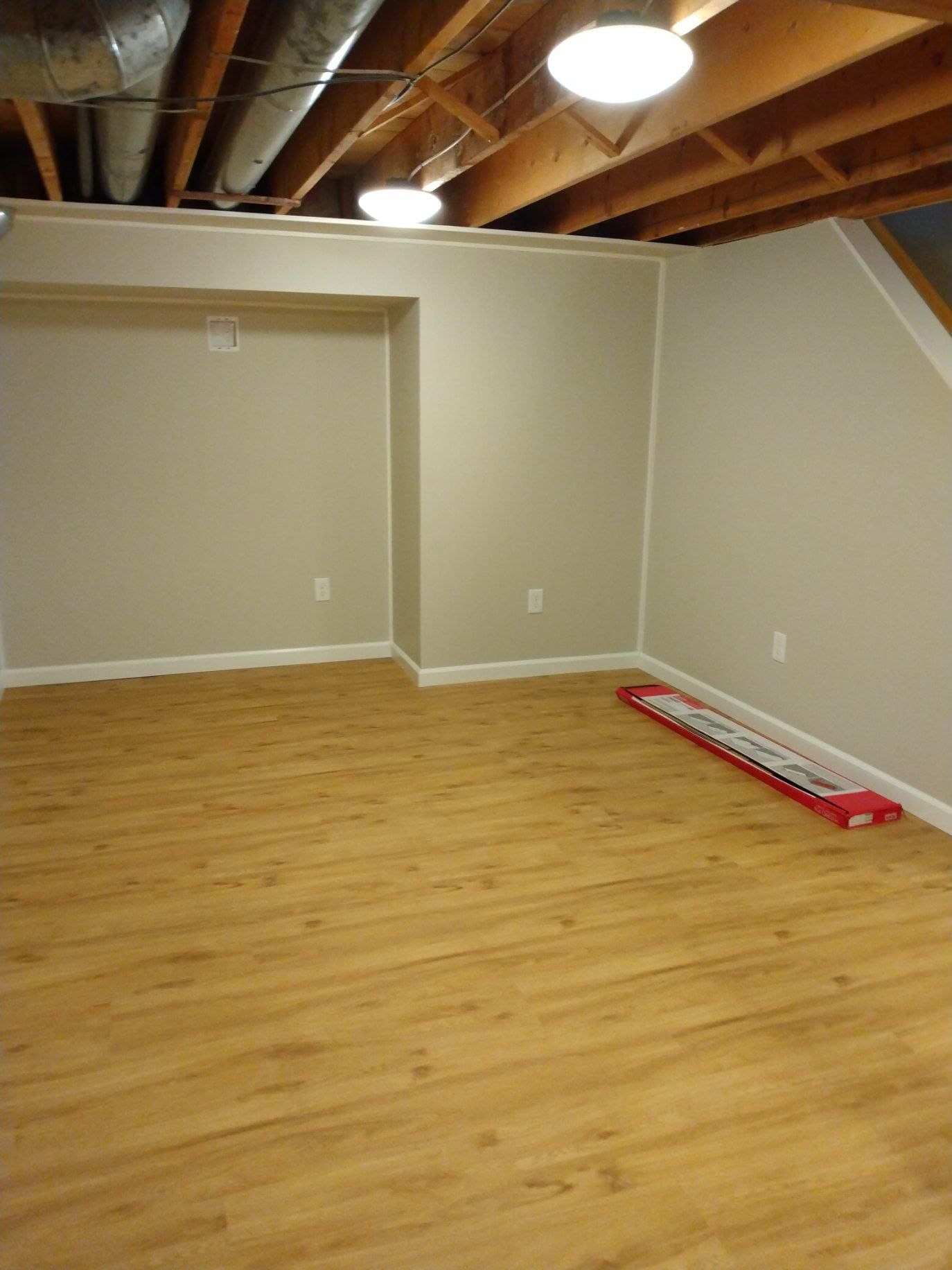 an empty room with wooden floors and white walls