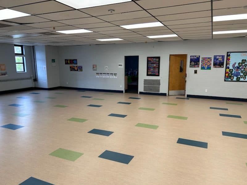 a large room with a tiled floor and posters on the wall .