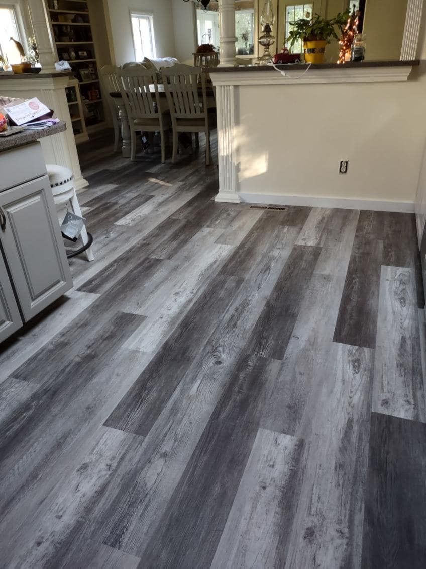 a kitchen with a wooden floor and white cabinets