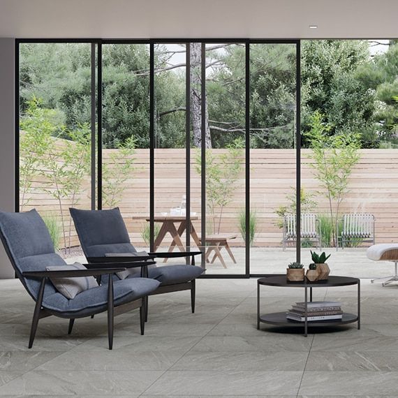 a living room with two chairs and a coffee table with a view of a patio .