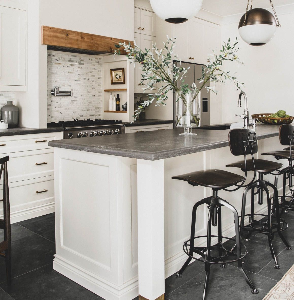 a kitchen with white cabinets and black counter tops
