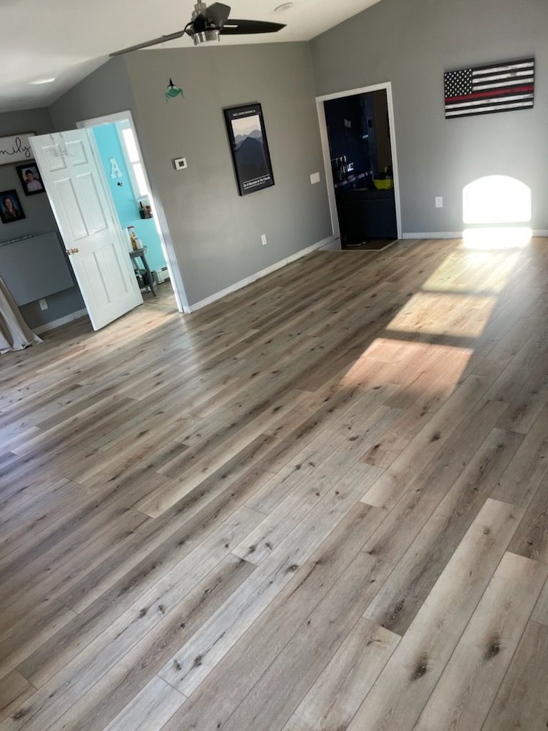A living room with hardwood floors and a ceiling fan.
