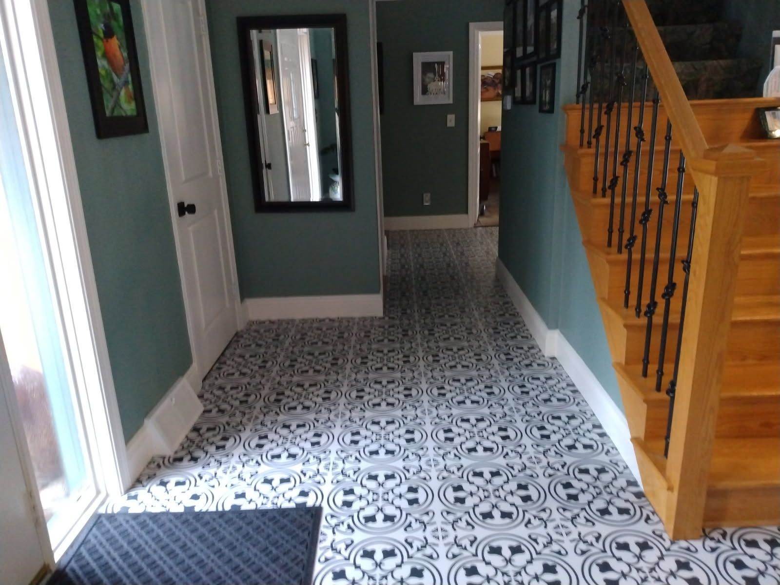 A hallway with stairs and a mirror on the wall