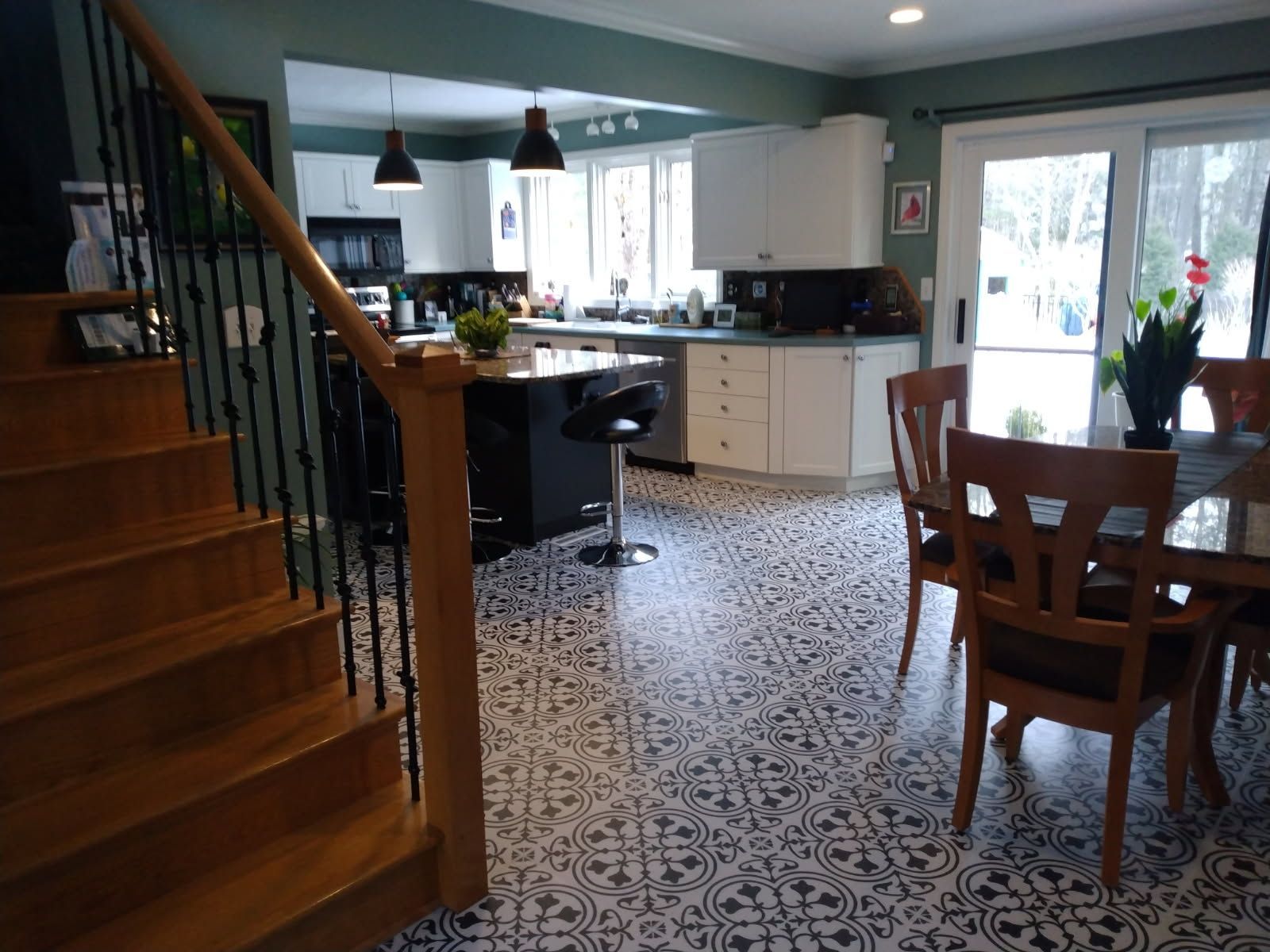 A kitchen with a table and chairs and stairs leading up to it.