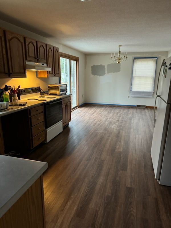 A kitchen with wooden floors and a stove and refrigerator