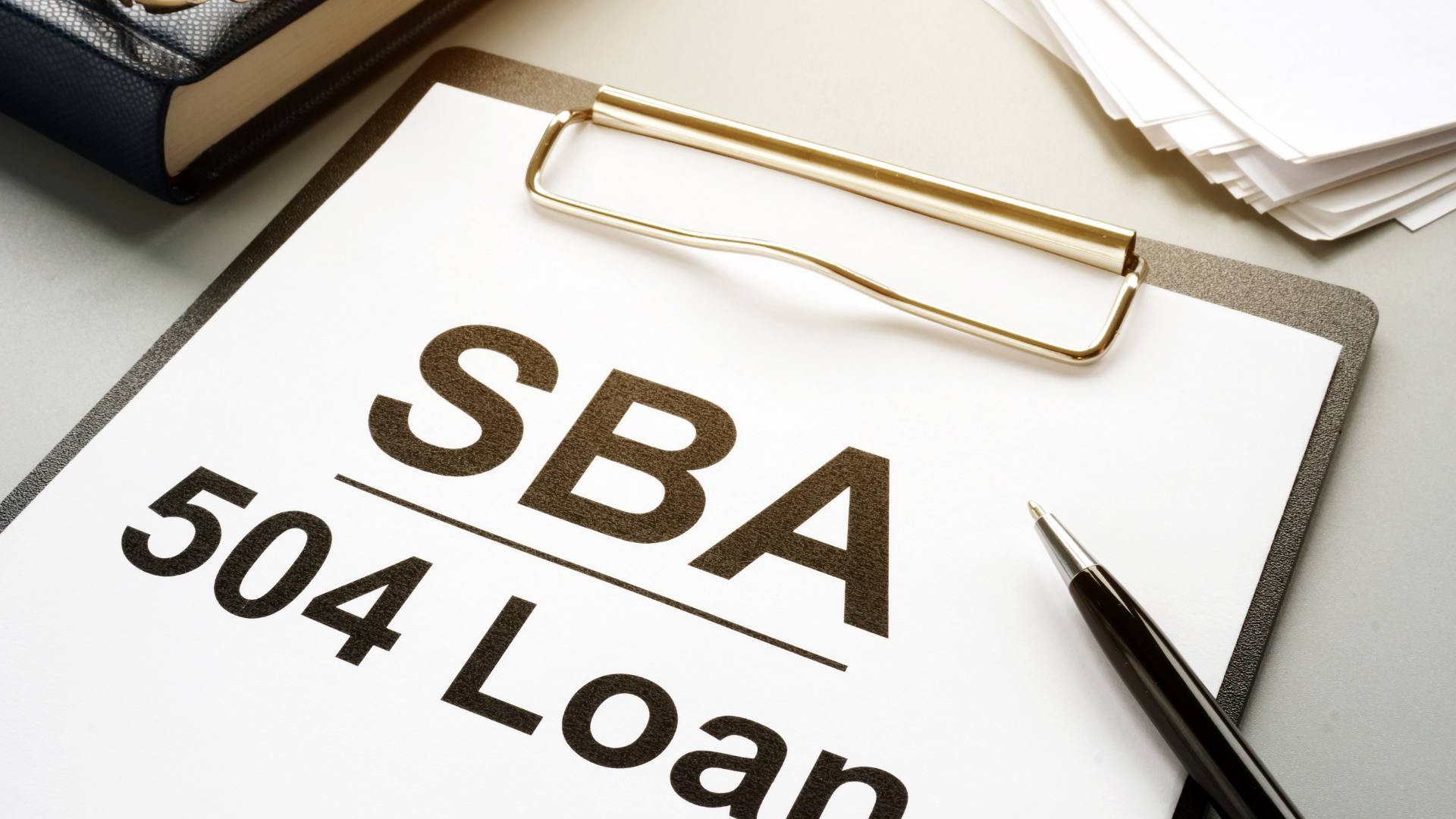 A clipboard with the words sba 504 loan written on it