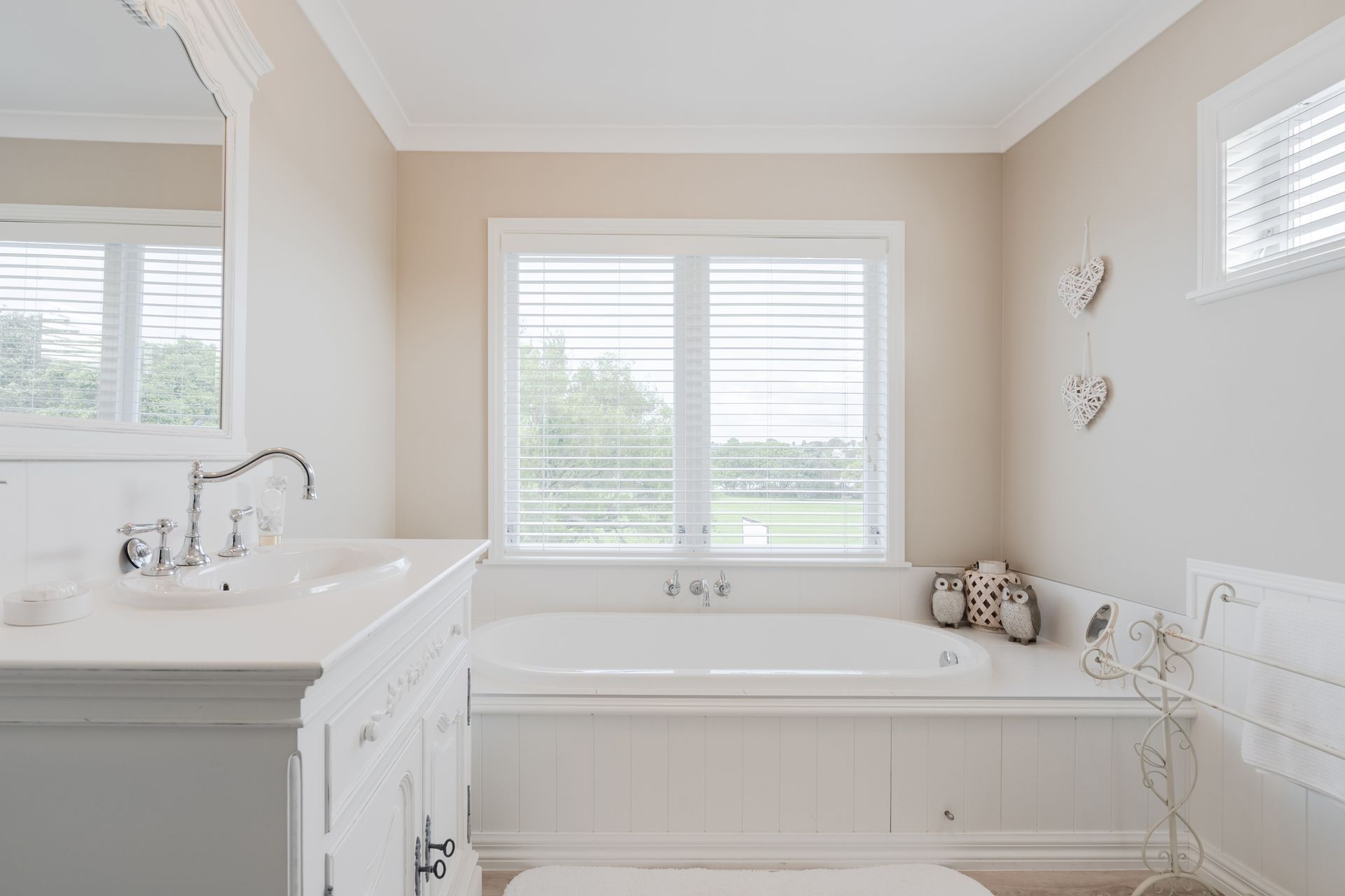 A bathroom with a tub, sink, mirror and window. A bathroom with a tub , sink , mirror and window.
