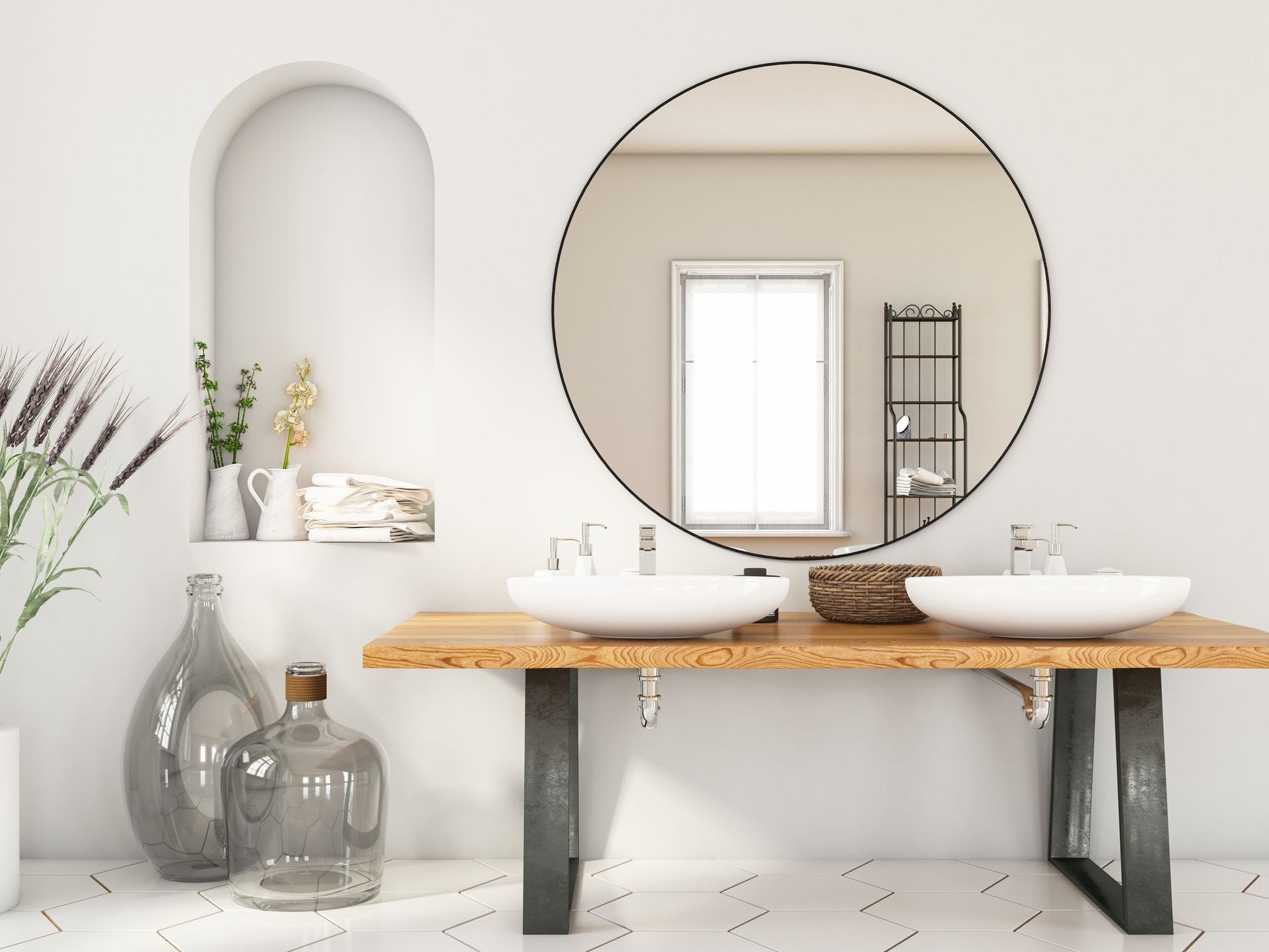 A bathroom with two sinks and a round mirror.
