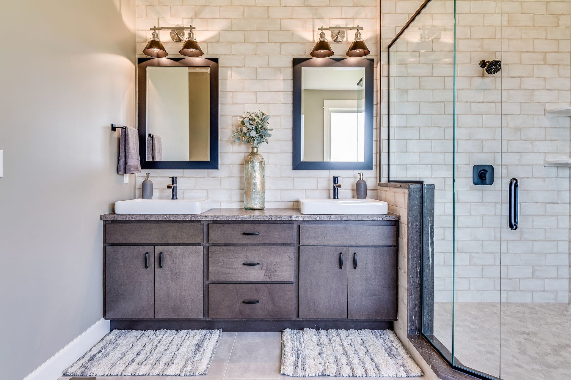 A bathroom with two sinks , two mirrors and a walk in shower. A bathroom with two sinks , two mirrors and a walk in shower.