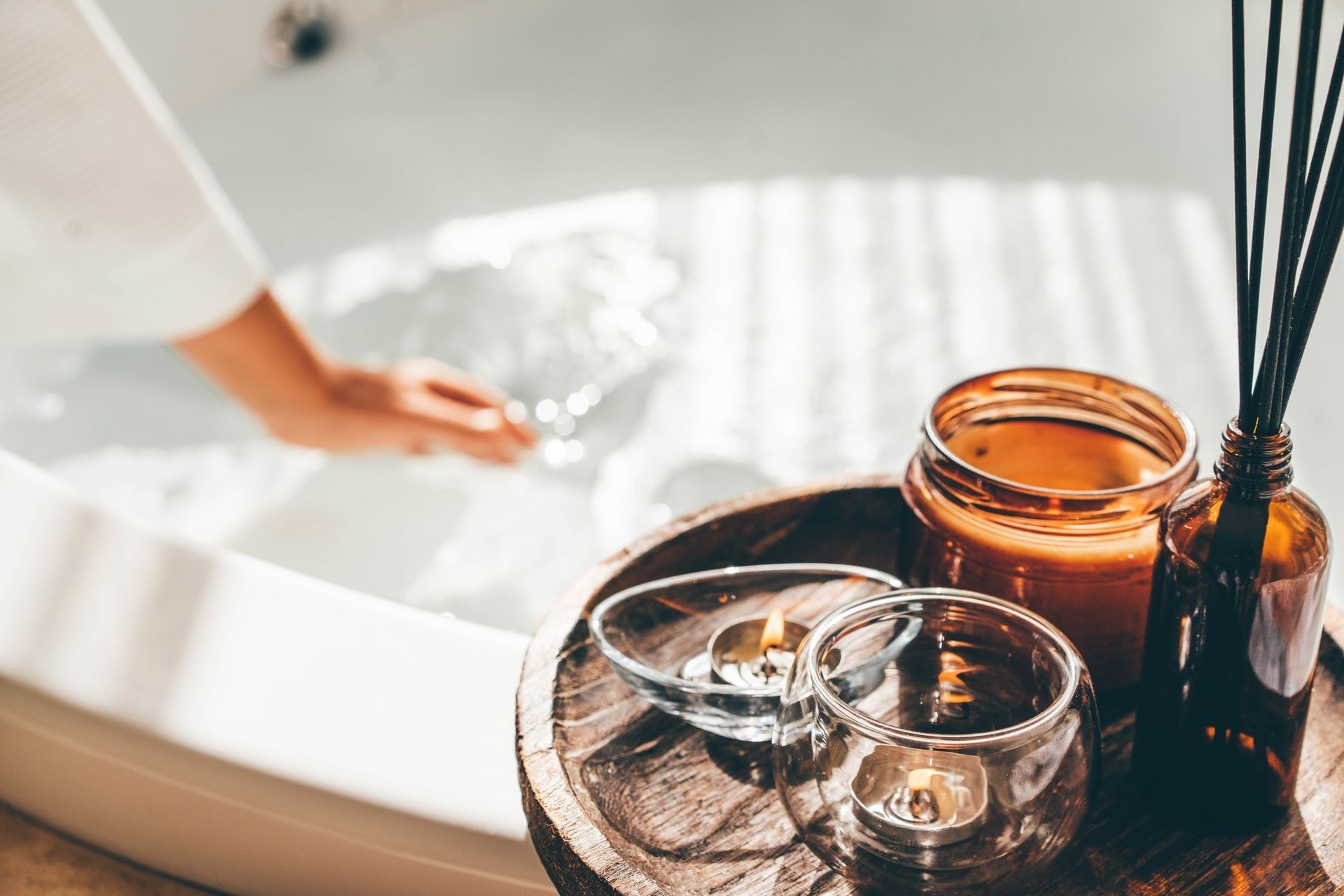 A woman is taking a bath in a bathtub with candles and reed diffusers. A woman is taking a bath in a bathtub with candles and reed diffusers.