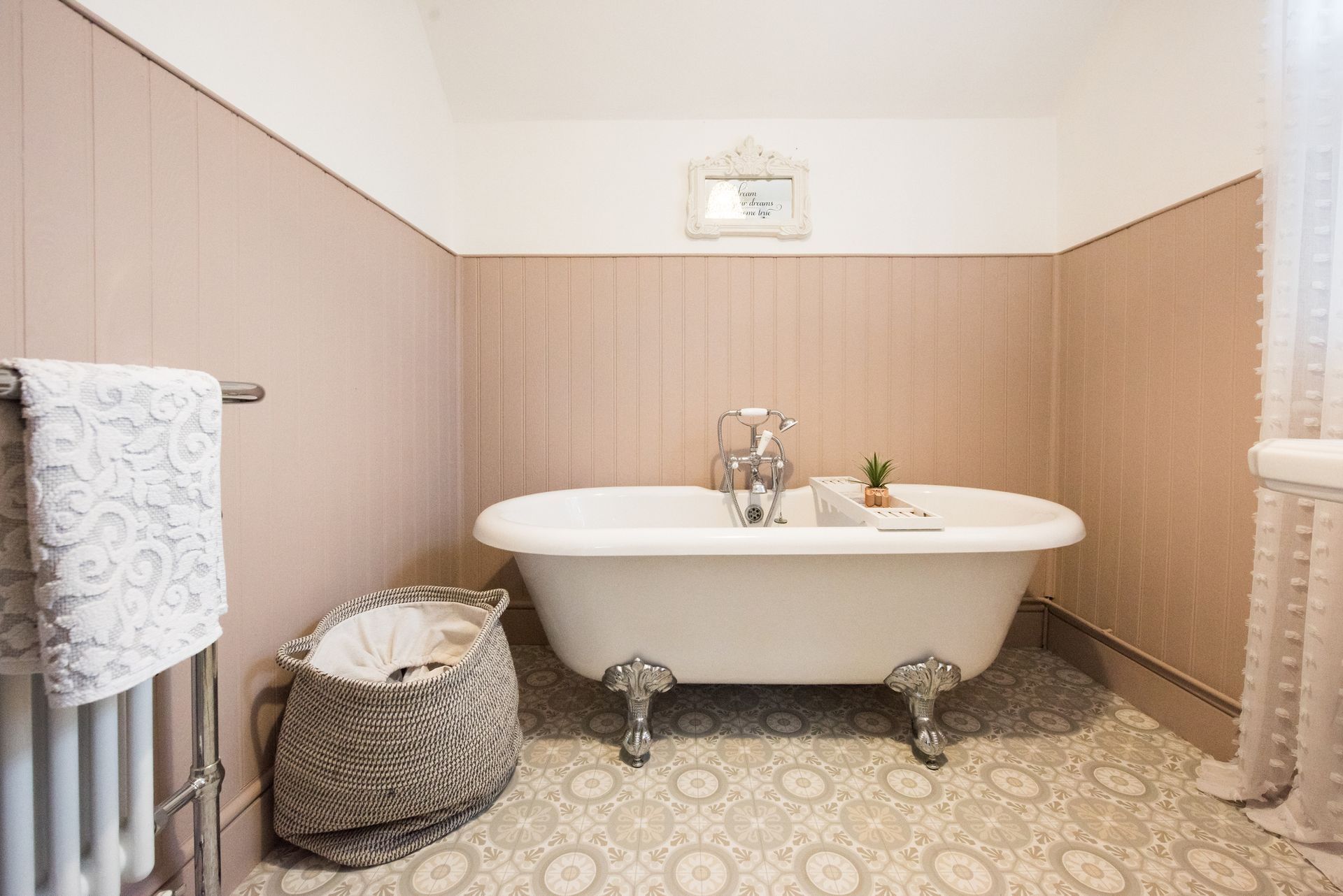 A bathroom with a bathtub and a basket on the floor. A bathroom with a bathtub and a basket on the floor.