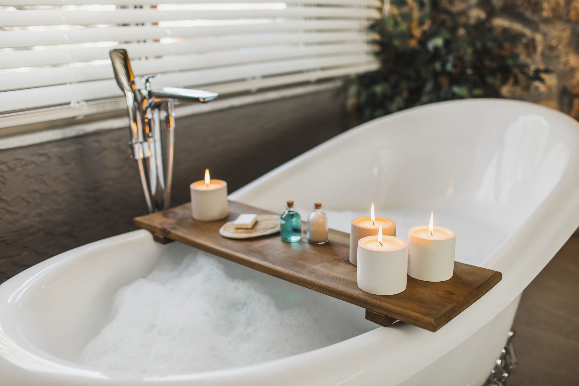 A bathtub with candles and soap on a wooden tray. A bathtub with candles and soap on a wooden tray.