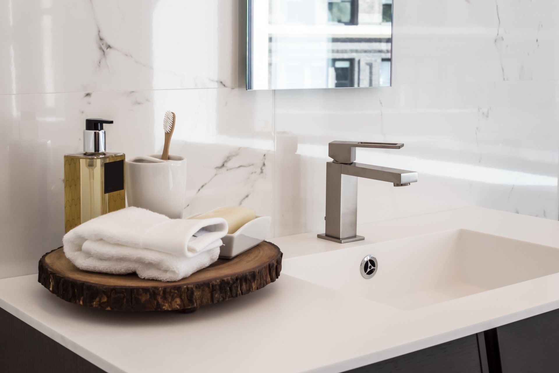 A bathroom sink with a wooden cutting board on top of it. A bathroom sink with a wooden cutting board on top of it.