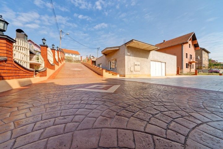 Curved cobblestone street with houses and a bright blue sky on a sunny day