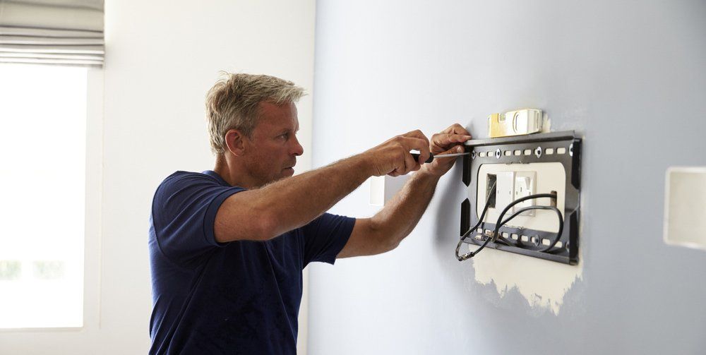 Electrician Installing Wall Bracket for a TV — Local Electrician in Port Stephens, NSW