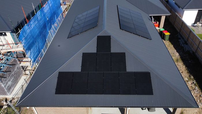 An aerial view of a house with solar panels on the roof.