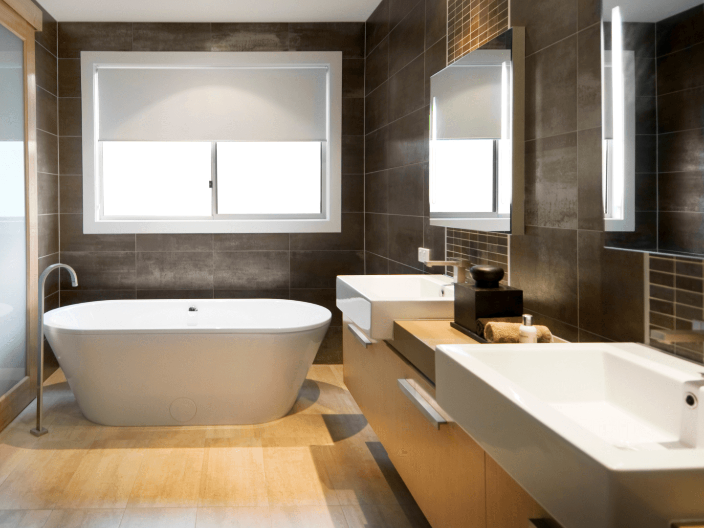 Remodeled bathroom with roman tub and twin sinks with vanity mirrors