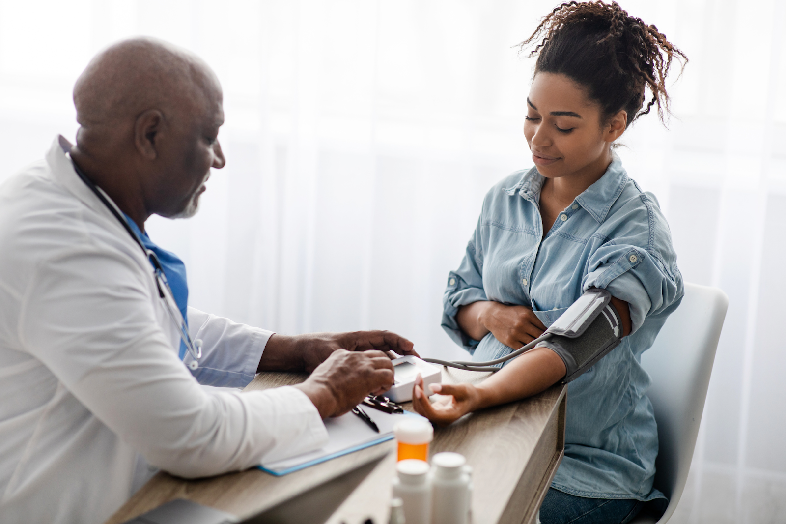 A doctor checks a woman’s blood pressure levels as part of her annual checkup. 