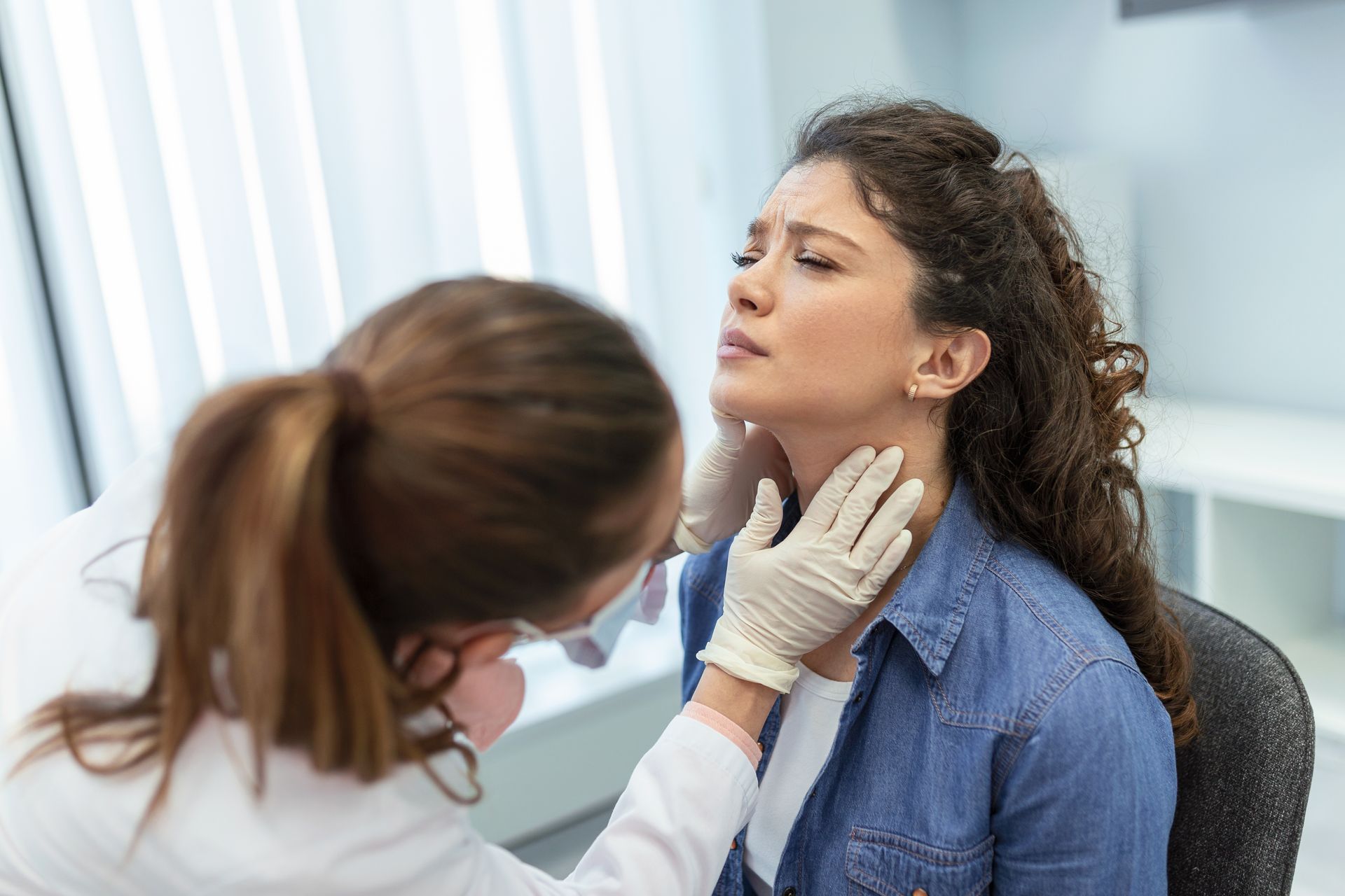 A healthcare professional examines a patient thoroughly to spot overactive thyroid symptoms.