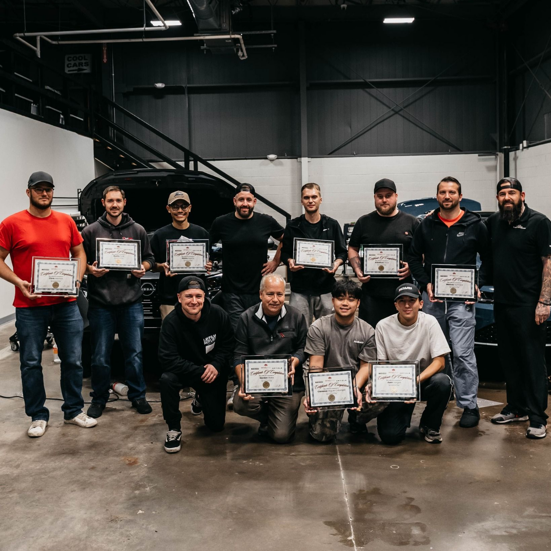 A group of men are standing next to each other in a store holding certificates.