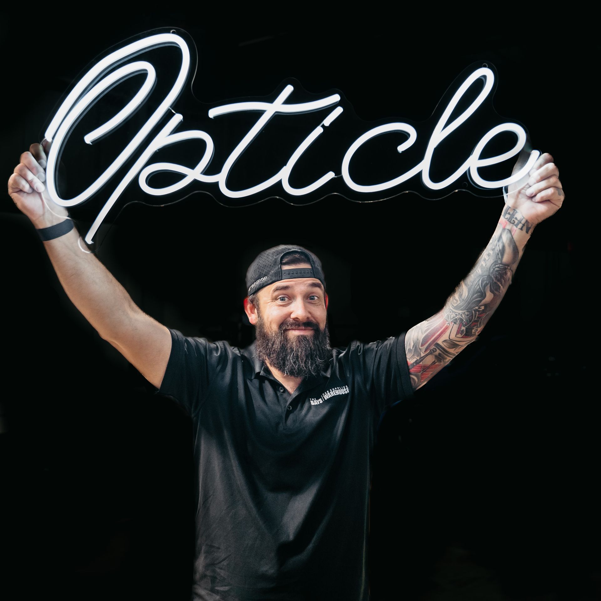 Man holding a neon sign that spells 