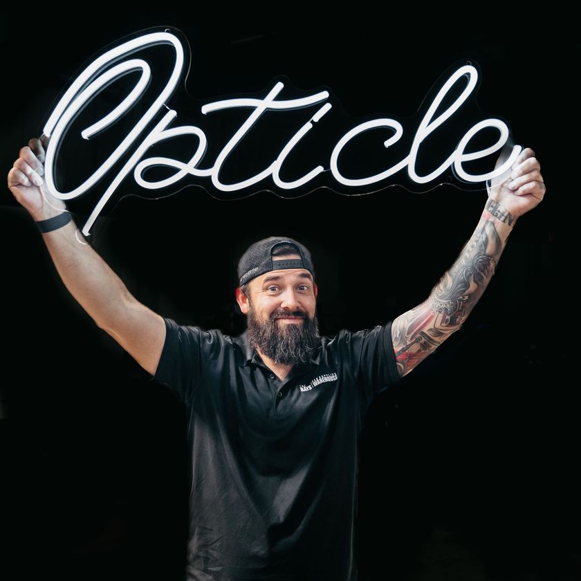 Man holding a neon sign that spells
