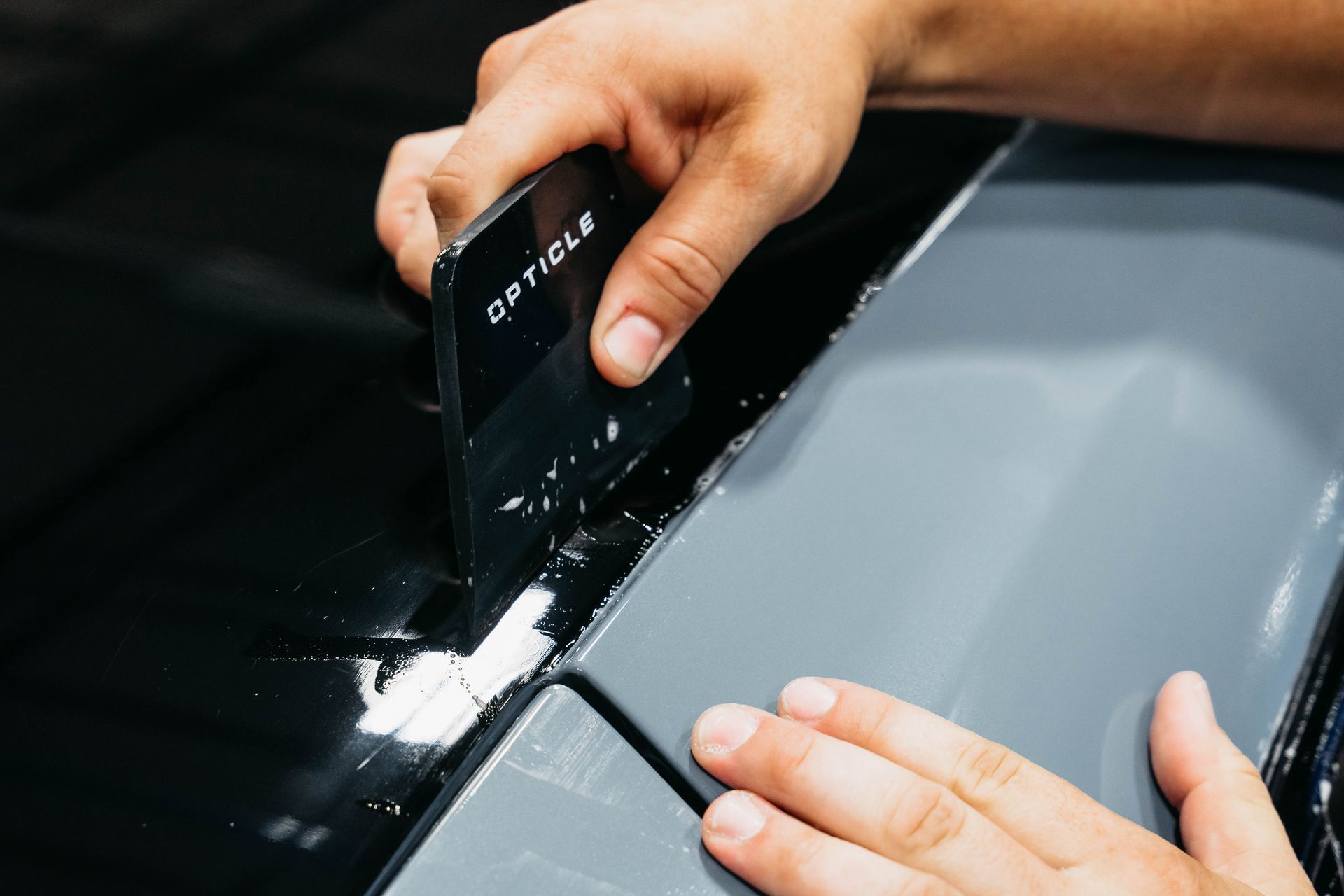 A man is installing black PPF