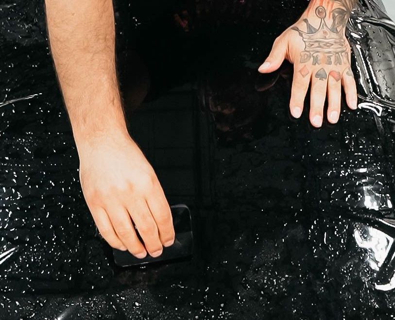 A man is installing black PPF