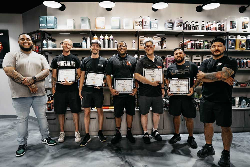 A group of men are standing next to each other in a store holding certificates.