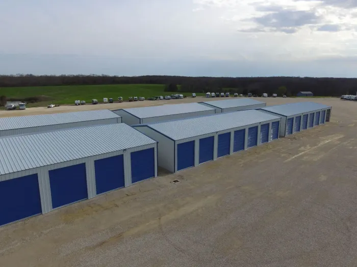 An aerial view of a row of storage units with blue doors.